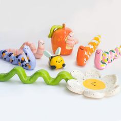 various toys are arranged in the shape of an apple, flower, and caterpillar