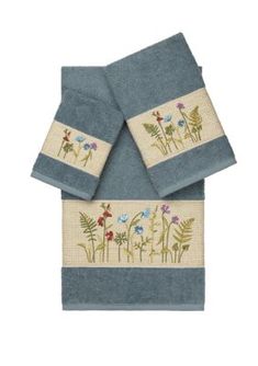 two blue towels with embroidered flowers on them