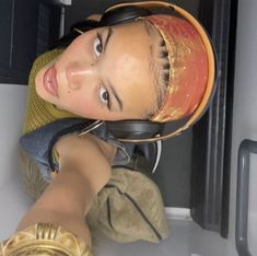 a young man wearing headphones sitting on top of a white counter next to a microwave oven