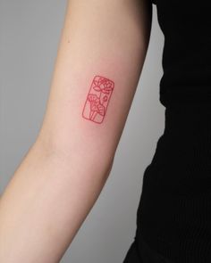 a woman's arm with a red ink tattoo on the left side of her arm