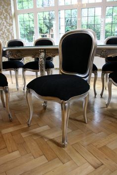 a dining room table and chairs with black upholstered cushions