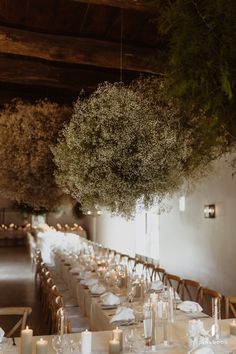 the tables are set with white linens and candles