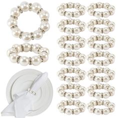 a white table setting with pearls and napkins