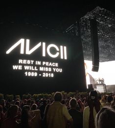 a large group of people standing in front of a sign that reads avicii rest in peace, we will miss you 1989 - 2016