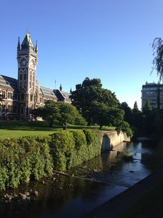 a large building with a tower next to a river