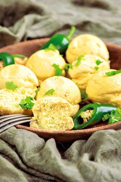 a wooden bowl filled with green vegetables on top of a table next to a fork