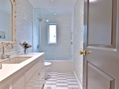 a bathroom with a checkered tile floor and white walls, along with an open door