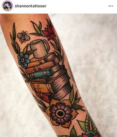 a tattoo with books and flowers on it