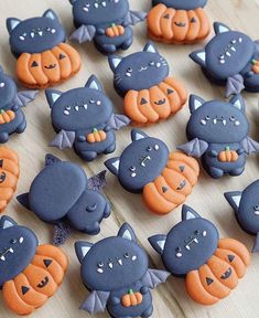 there are many decorated cookies that look like cats and pumpkins on the table together