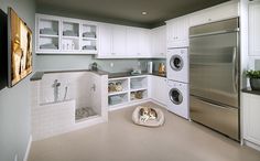 a laundry room with white cabinets and stainless steel appliances