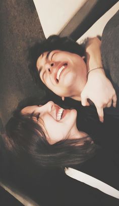 two people are laying on the floor and smiling