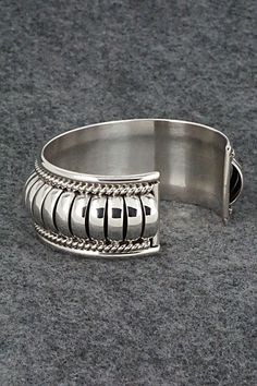 This stunning sterling silver bracelet was made by Navajo silversmith Thomas Charley. The inside is signed TC and stamped sterling.Size: 5 1/4" (will fit up to a 6 1/2" wrist)Gap: 1 1/4"Width: 1"Free shipping on all orders! We ship with USPS and always include tracking. All orders ship within a day of payment.Returns are accepted up to 30 days after you receive your order. Just send us a message. Our shop offers cash back or store credit. The item must be returned in new condition. Silver Southwestern Style Cuff Bracelet For Formal Occasions, Southwestern Hallmarked Silver Jewelry, Southwestern Style Polished Bangle, Southwestern Sterling Silver Polished Bangle Bracelet, Southwestern Sterling Silver Bangle With Polished Finish, Southwestern Polished Sterling Silver Bangle, Southwestern Style Silver Round Cuff Bracelet, Silver Southwestern Style Bracelet With Oyster Clasp, Sterling Silver Southwestern Round Cuff Bracelet