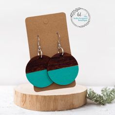 two tone wooden earrings with turquoise and brown wood in front of a card board holder