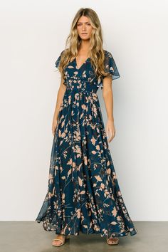 This gorgeous navy maxi gown is perfect for all seasons! The beautiful flow of the material and deep V neckline will have you feeling whimsical. V-neck Chiffon Printed Dresses, Chiffon Maxi Dress With Floral Print And Surplice Neckline, Flowy Chiffon Dress With Floral Print And Short Sleeves, Chic Flowy Maxi Dress With Butterfly Sleeves, Green Maxi Dress With Floral Print And Flutter Sleeves, Chiffon Maxi Dress With Short Sleeves And Print, V-neck Chiffon Maxi Dress With Print, Chiffon Flutter Sleeve Dress For Brunch, Flowy Printed Dress With Flutter Sleeves