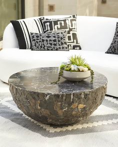 a white couch sitting next to a table on top of a rug