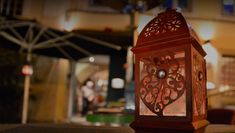 a red lantern sitting on top of a table in front of a building at night