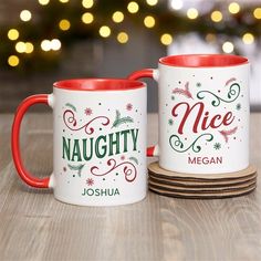 two red and white coffee mugs sitting next to each other on a wooden table