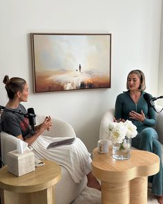 two women sitting on couches talking to each other in front of a tv camera