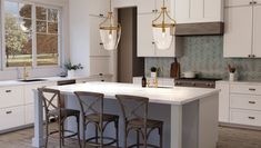 a kitchen with white cabinets and marble counter tops, two bar stools at the center