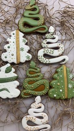 decorated cookies are arranged in the shape of christmas trees and serpents on top of each other