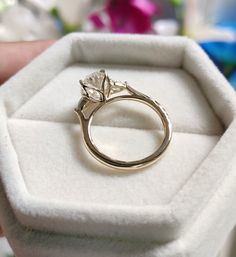 a gold ring sitting in a white box