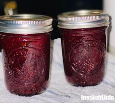 two jars filled with red liquid sitting on top of a table