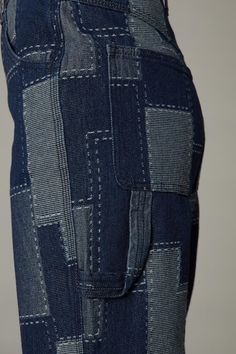 the back view of a woman's pants with patchwork on it and pockets