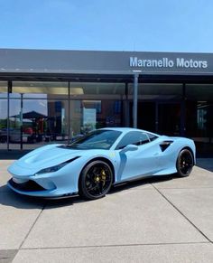 a blue sports car is parked in front of a dealership with the name marmelo motors on it