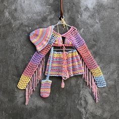 a crocheted sweater hanging on a wall