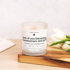 a white candle sitting on top of a wooden cutting board