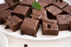 there are many pieces of chocolate on the plate and one piece has a green leaf