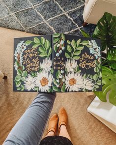 a person holding up an open book with flowers on it