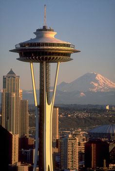 the space needle in seattle, usa with snow - capped mountains in the back ground