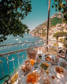 an image of a table with food on it and the ocean in the back ground