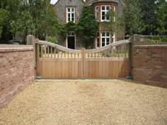 a wooden fence in front of a brick house