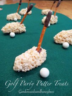 rice krispy treats with golf tees and balls on a green tableclothed surface