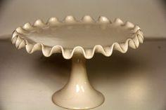 a white cake plate sitting on top of a table