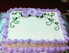 a sheet cake with purple frosting and flowers on it