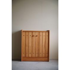 a wooden cabinet sitting against a white wall