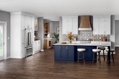 a kitchen with white cabinets and blue island