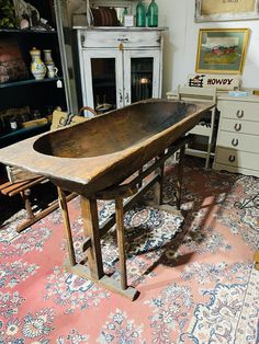 an old wooden table sitting on top of a rug