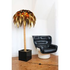 a black chair sitting next to a tall palm tree