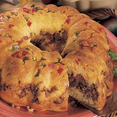 a bundt cake on a red plate with a slice cut out and ready to be eaten