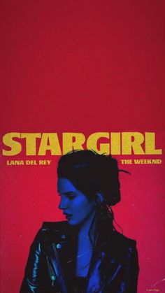 a woman in black leather jacket standing next to a red and yellow wall with the words stargirl on it