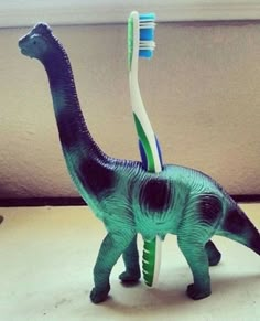 a toy dinosaur with a toothbrush in it's mouth