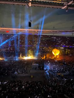 a large crowd at a concert with bright lights