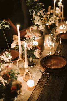 the table is set with candles, flowers and other items for an elegant dinner party