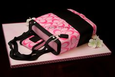 a pink and black bag cake on top of a table