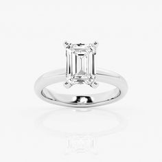 an emerald cut diamond ring on a white background