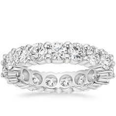 a white gold ring with round cut diamonds on the sides and four rows of stones